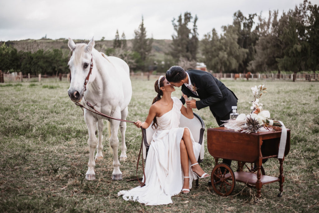 Wedding couple kissing at wedding venues on oahu with horse