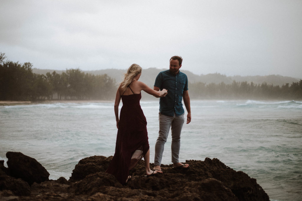 misty ocean with couple walking on the rocks