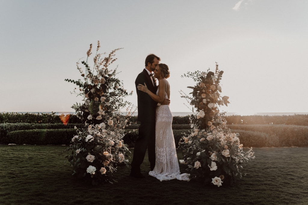 four season ceremony florals with couple hugging