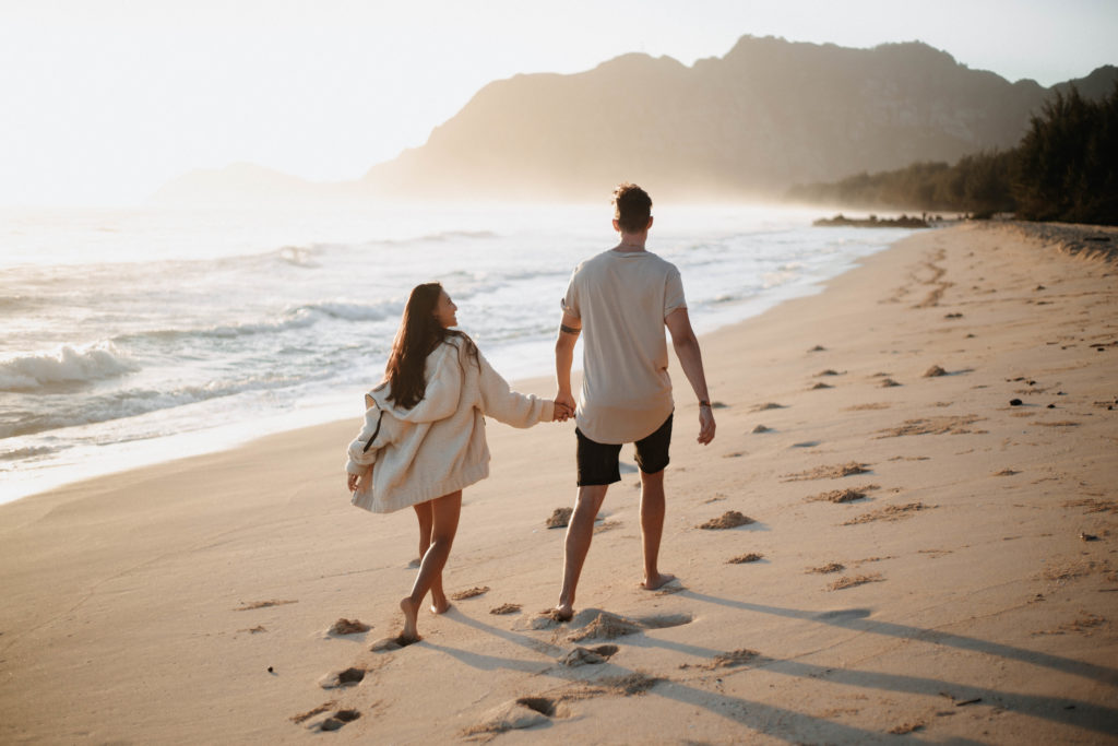 sunrise with couple walking on the sand