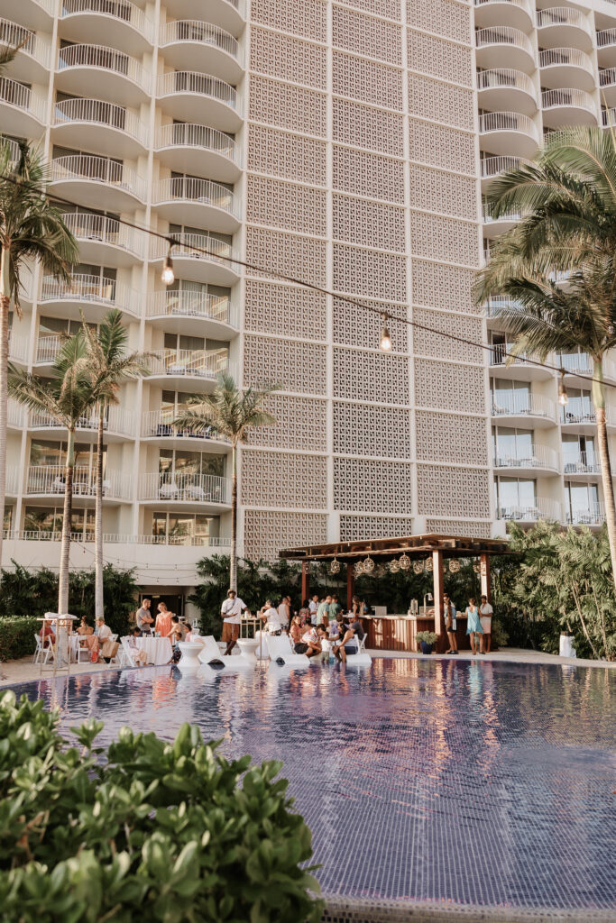 A couple enjoying a themed post-wedding pool party with friends.