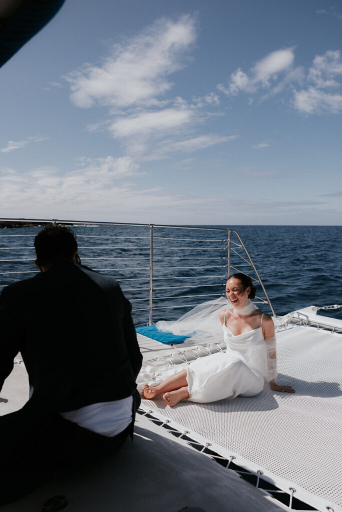 Bride laughing on a catamaran in Hawaii captured on film.