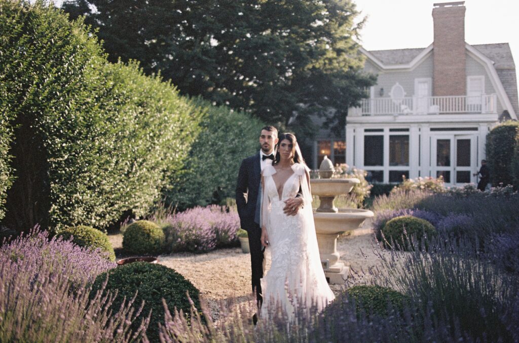 Bride and groom embracing facing forward in a lavender garden at a private estate wedding in the Hamptons, captured on 35mm film