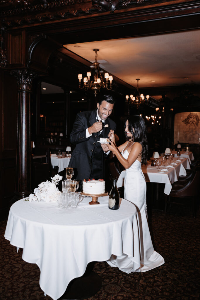 Bride and groom sharing cake at HiSteaks Hawaii, a stylish restaurant wedding venue in Honolulu perfect for intimate receptions